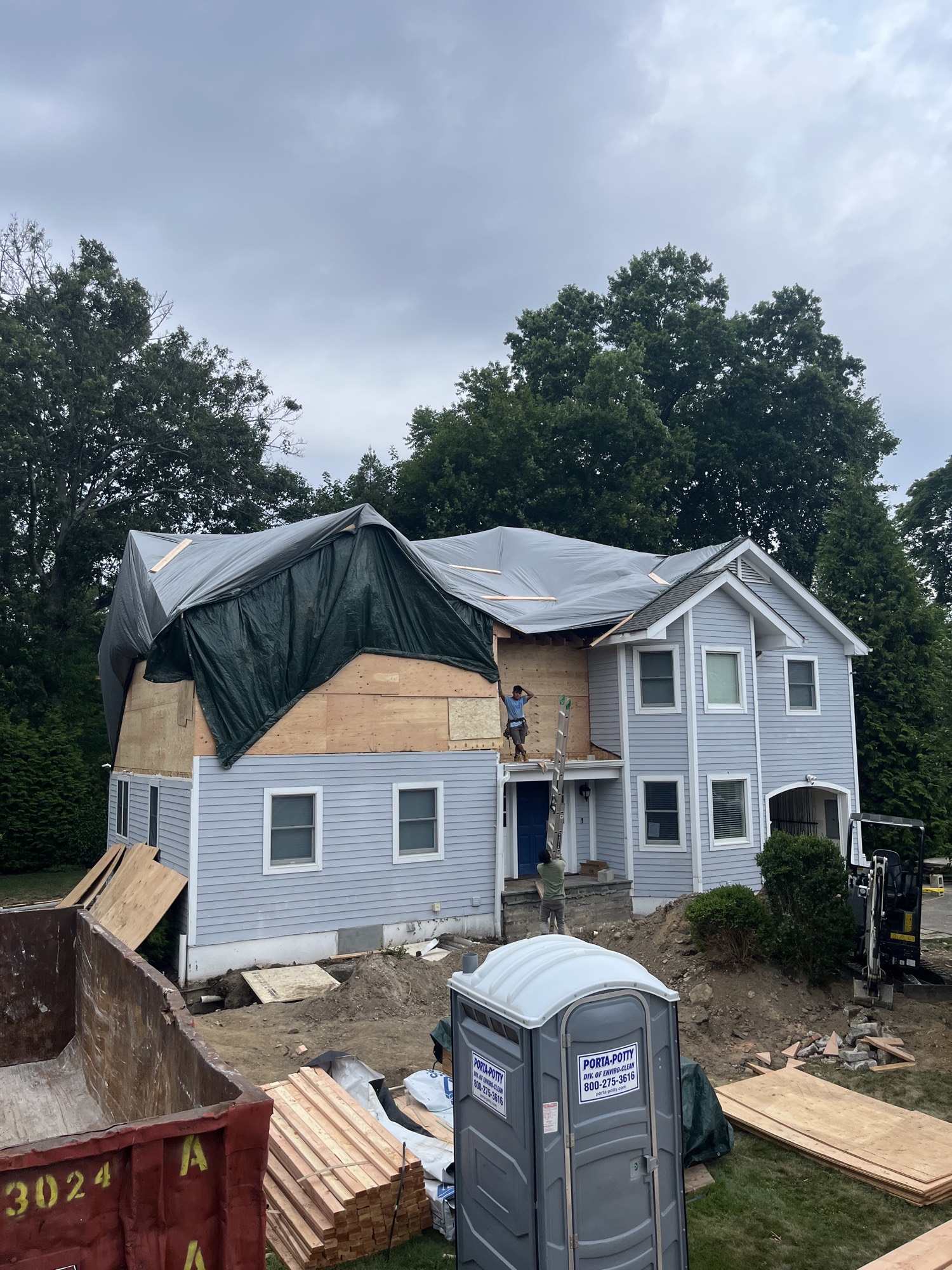 House with roof and siding torn open and tarped during renovation